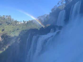 Scenic view of waterfall against sky