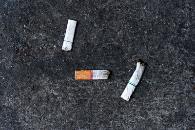 High angle view of cigarette butts on road