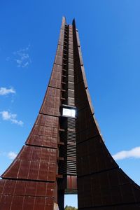 Low angle view of modern building against blue sky