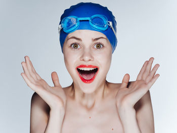 Portrait of shirtless young woman against white background