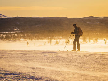 View of man skiing at sunset