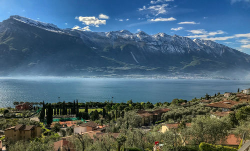 Scenic view of townscape by sea against sky