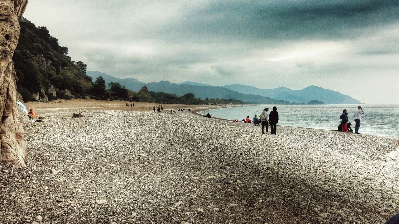 sky, cloud - sky, mountain, cloudy, water, sea, beach, lifestyles, leisure activity, scenics, men, person, tranquil scene, cloud, tourist, large group of people, beauty in nature, tranquility, vacations