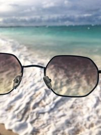 Close-up of sunglasses on beach