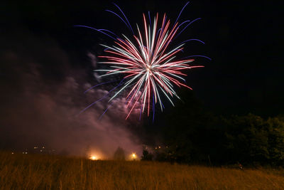 Low angle view of firework display at night