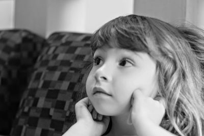 Close-up portrait of girl looking away at home