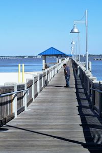 Senior man standing on footbridge by sea