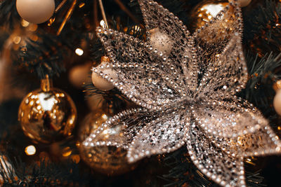 Christmas tree decorated with golden festive christmas balls and crystal snowflake decoration.