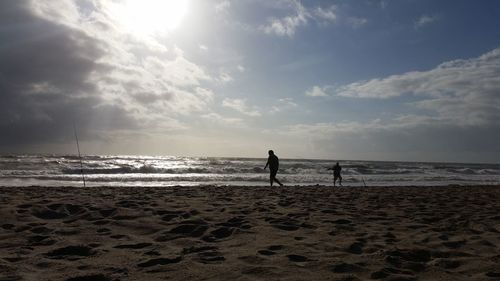 People standing on beach against sky