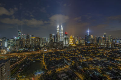 Illuminated cityscape against sky at night