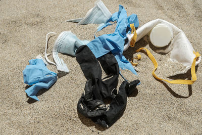 Mask and plastic gloves,disposable medical garbage on sea coast,covid pollution