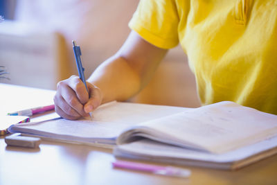 Midsection of person reading book on table