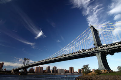 Low angle view of suspension bridge against sky