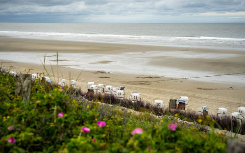 Scenic view of beach by sea against sky