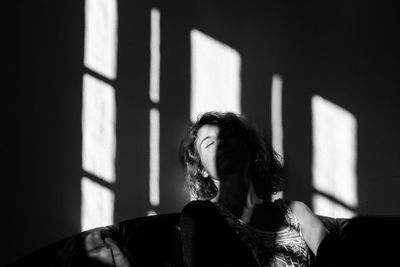 Young woman with shadow on wall