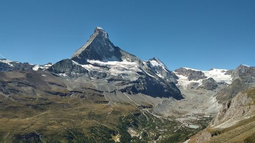 Scenic view of snowcapped mountains against clear blue sky