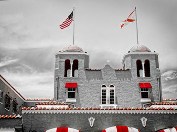 Low angle view of flags on building against sky