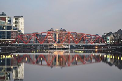 Bridge over river in city against clear sky