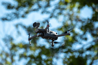 Low angle view of drone flying against sky