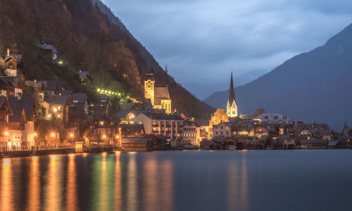 Illuminated buildings in city against sky