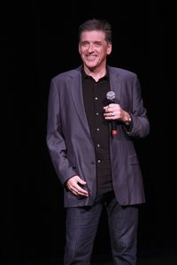 Mid adult man standing against black background