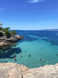 High angle view of rocks in sea against blue sky