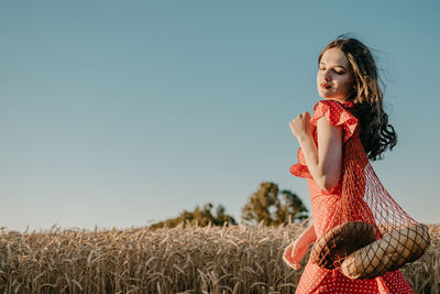 Woman standing on field against sky