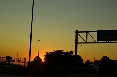 Silhouette cars on road against sky during sunset