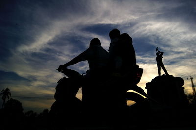 Low angle view of silhouette statue against sky