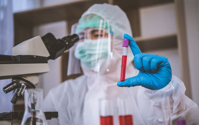 Close-up of doctor examining over microscope