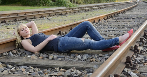 Full length of woman lying on railroad track