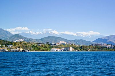Scenic view of sea by buildings against sky