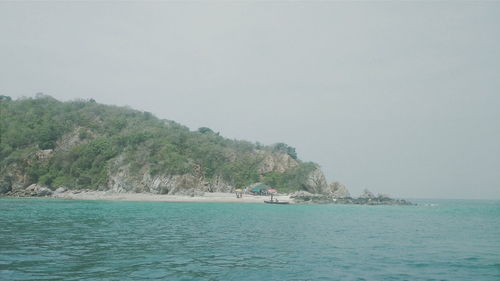 Boat sailing in sea against clear sky