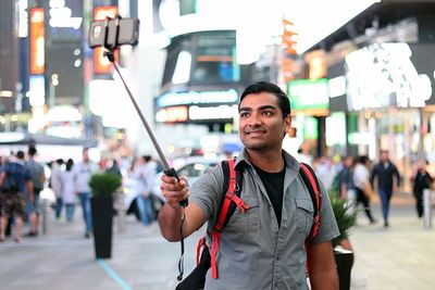 Portrait of young man standing in city