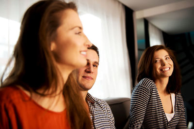 Close-up of smiling friends at home