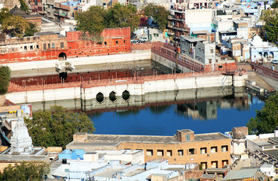 High angle view of buildings and pond on sunny day in city