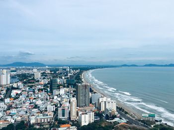 High angle view of buildings by sea against sky