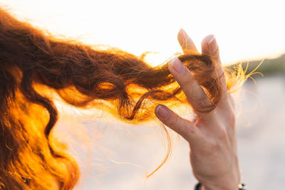 Cropped image of hand playing with curly hair