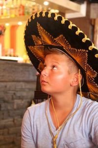 Boy looking up while wearing sombrero