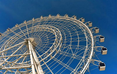 Low angle view of ferris wheel against blue sky