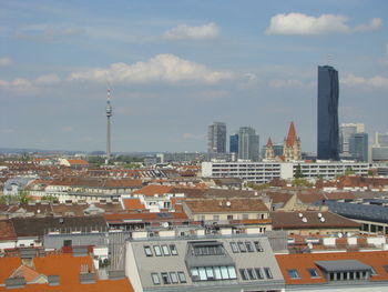 Aerial view of buildings in city against sky