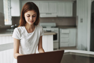 Young woman using phone while standing on table