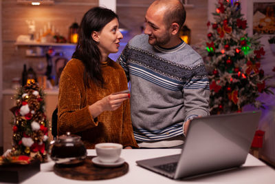 Rear view of man and woman using smart phone