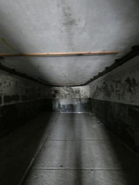 Empty walkway in illuminated tunnel