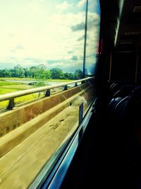 Cars on road against cloudy sky