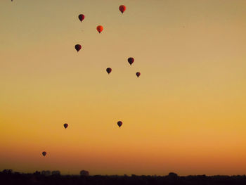 Low angle view of hot air balloons against sky during sunset