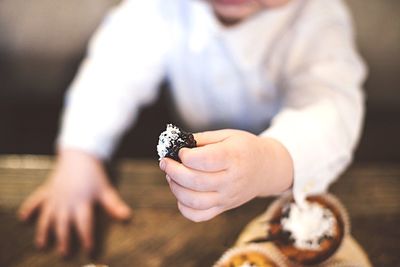 Midsection of child holding blackberry fruit