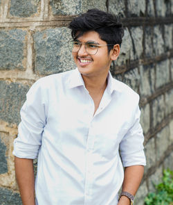 Portrait of smiling man standing against wall