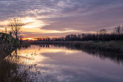 Scenic view of lake against sky at sunset