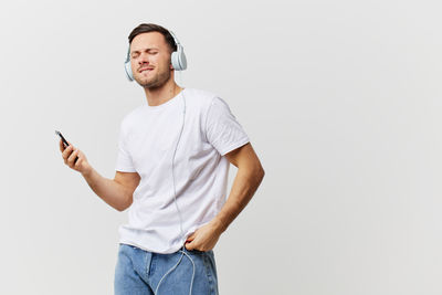 Portrait of young man standing against white background